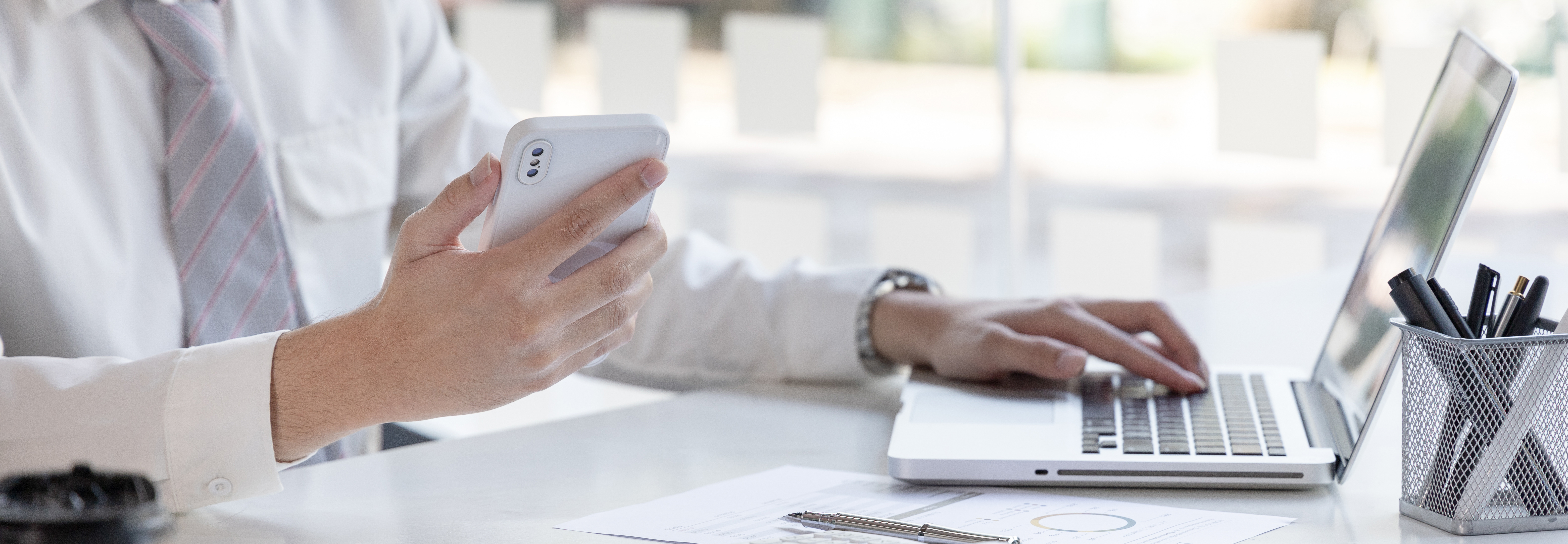 dirigeant qui gère l'administratif sur son ordinateur et son téléphone